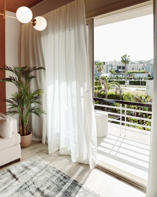 a living room with a sliding glass door with a balcony at BirdNest at Sheikh Zayed in Sheikh Zayed
