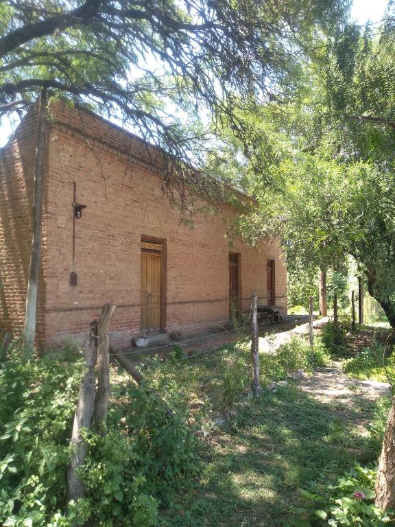 an old brick building with a fence in front of it at Casa alma verde alegria in Luyaba