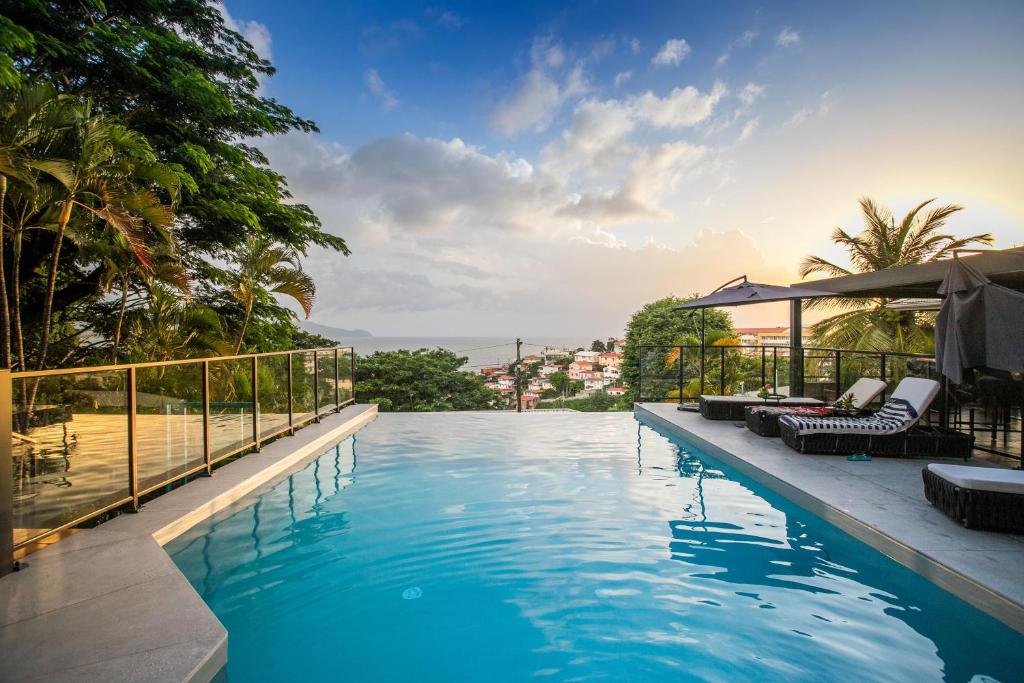uma piscina com espreguiçadeiras ao lado de um resort em Karibea Squash Hôtel em Fort-de-France