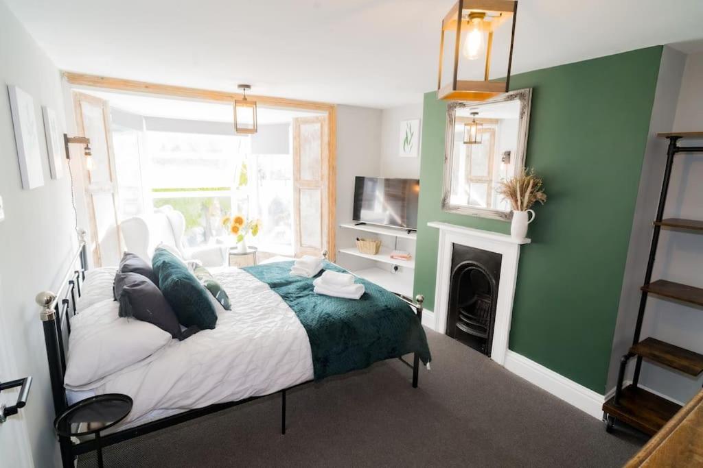 een slaapkamer met een bed met een groene muur bij Stunning 3 bed Home, 5 mins from Margate Beach in Kent