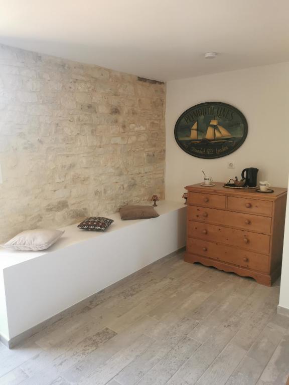 sypialnia z białym łóżkiem i drewnianą komodą w obiekcie Le Pigeonnier de coupiac w mieście Gourdon