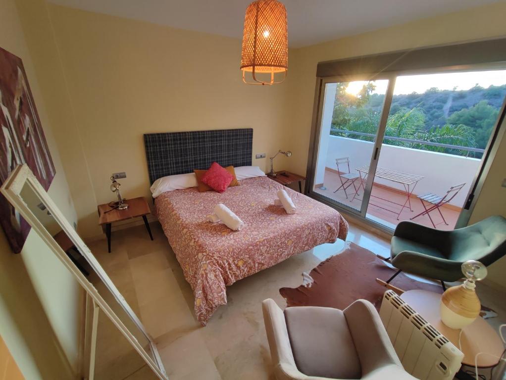 1 dormitorio con cama y vistas a un balcón en Villa Aguilas Club Guest house, en Málaga