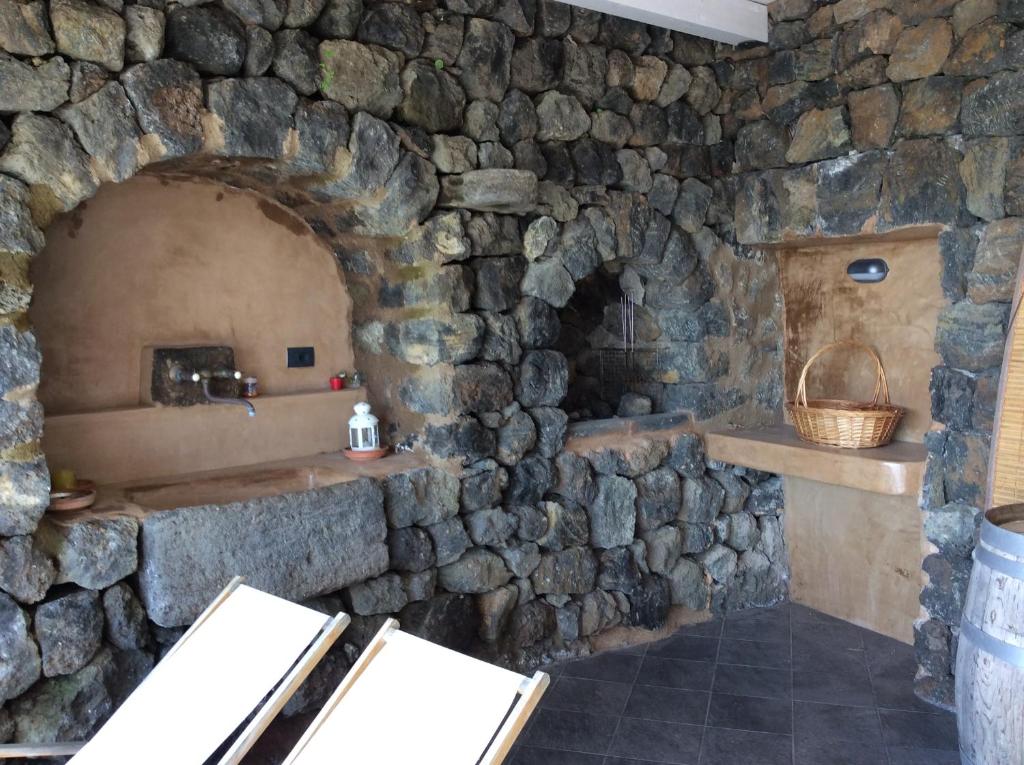 Baño de piedra con pared de piedra y horno de piedra en Residenza Venus Dream en Pantelleria