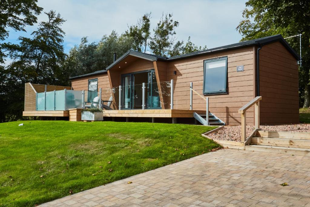 una casa con un gran patio con una casa en Letham Feus Lodge and Caravan Park, en Fife