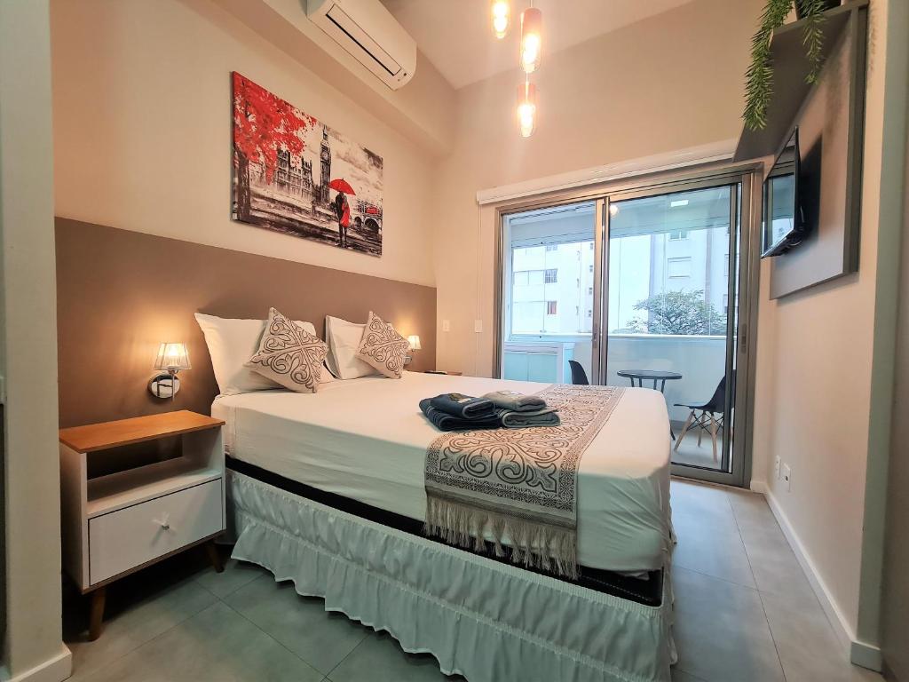 Un dormitorio con una cama grande y una ventana en E-Side Vila Madalena perto do Metrô, en São Paulo