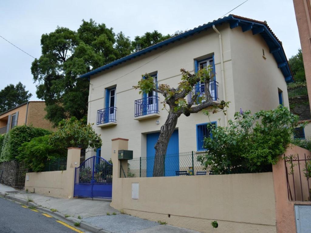 Maison Collioure, 4 pièces, 6 personnes - FR-1-225-684 في كولِيور: بيت ابيض شبابيكه ازرق واشجار