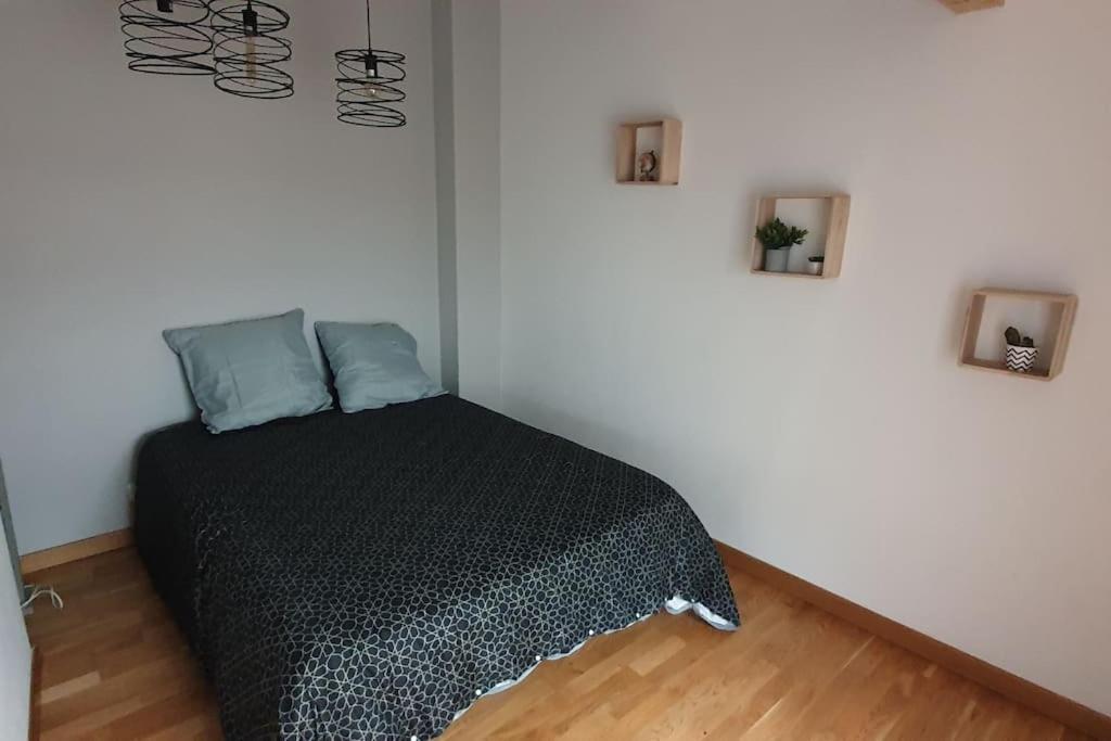 a bedroom with a black bed in a room at Sweet LOFT A PERIGNAT !!! in Pérignat-sur-Allier