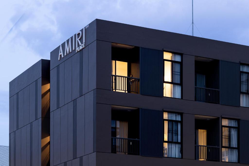 a black building with the ammine sign on it at AMIRI PLACE HOTEL in Chiang Mai