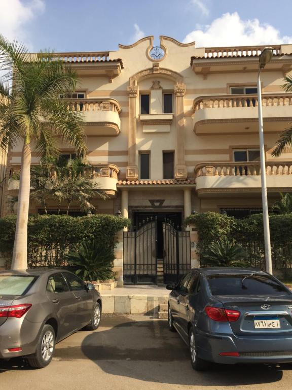 deux voitures garées devant un bâtiment dans l'établissement ڤيلا الميراچ Meriage, au Caire