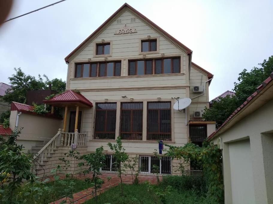 a large white house with windows and a staircase at Seymur’s house in Quba