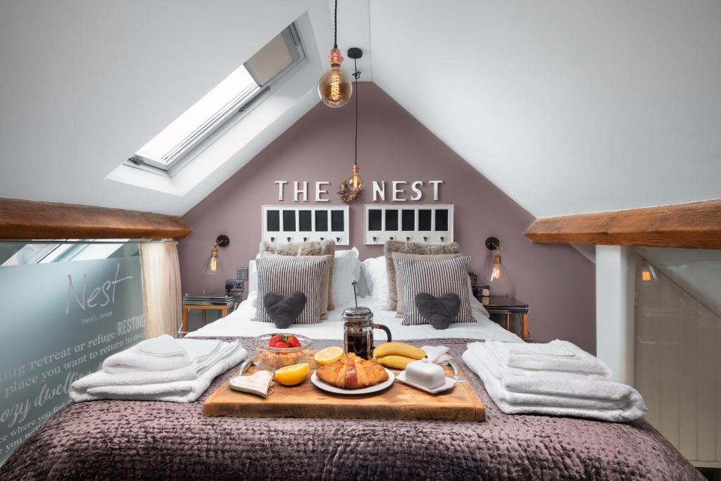 a bedroom with a bed with a tray of food on it at The Nest Barnlette in Wrenbury