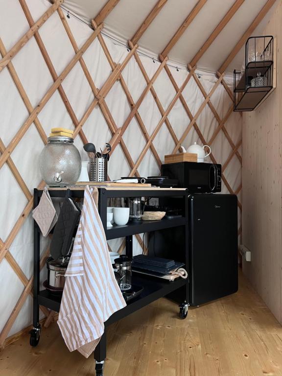 um quarto com uma prateleira preta numa tenda em Yary Yurt em Všeruby