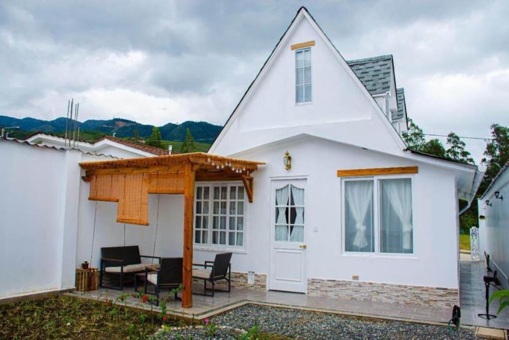 uma casa branca com um telhado inclinado e um pátio em "HOLLY HOUSE" 2 habitaciones - 2 bedrooms em Chachapoyas