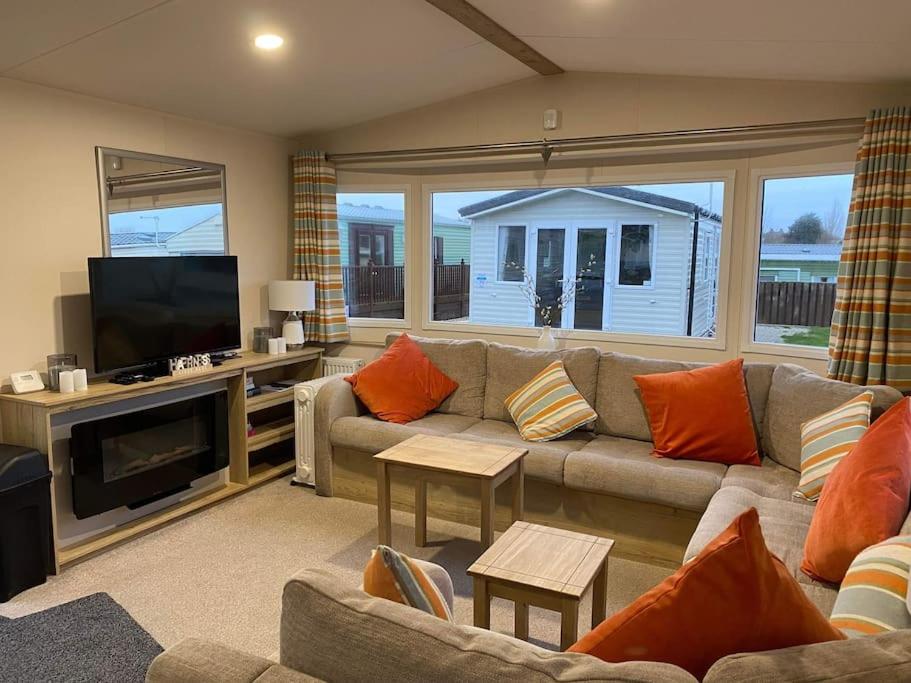 a living room with a couch and a flat screen tv at A family-friendly, eight birth, 2019 Abbey Trieste Caravan in Morecambe