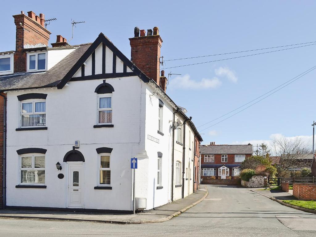 a white house on the side of a street at Coble Cottage - 28317 in Flamborough