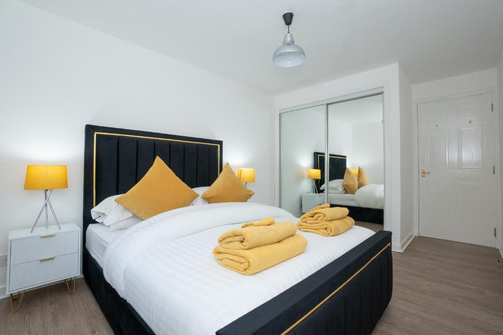 a bedroom with a large white bed with yellow pillows at Pavlova House - Luxury 2 Bed Apartment in Aberdeen City Centre in Aberdeen