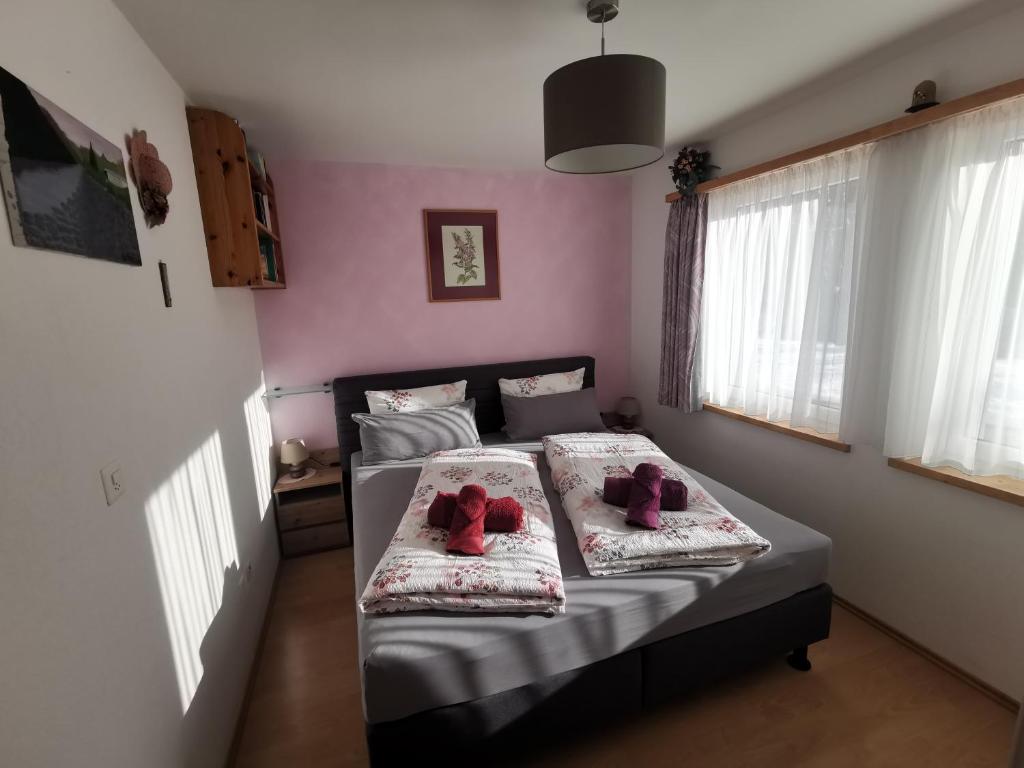 a bedroom with a bed with two teddy bears on it at Ferienwohnung Aquileia in Scuol