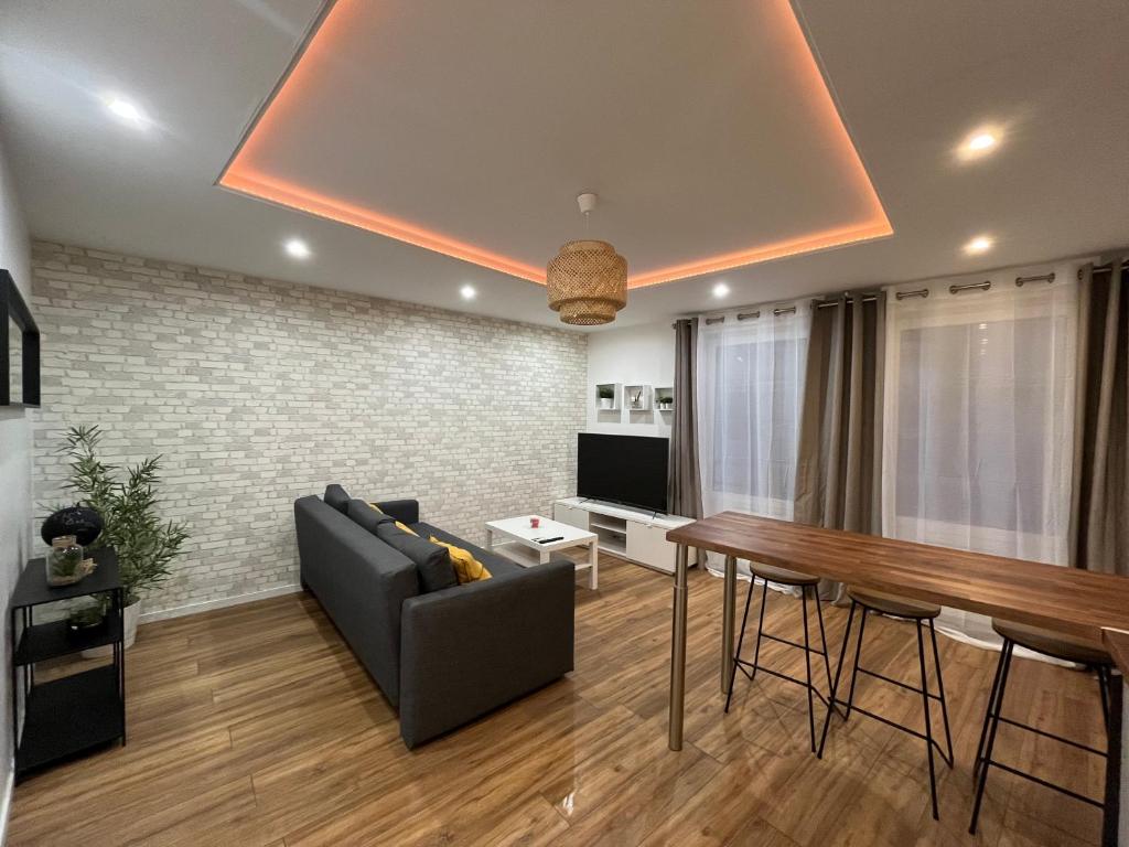 un salon avec un canapé et une table dans l'établissement Moderne appartement - Gare - centre-ville, au Mans