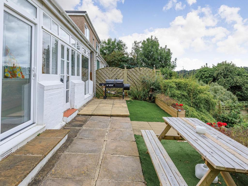 a backyard with a picnic table and a grill at West Brae in Bishops Tawton