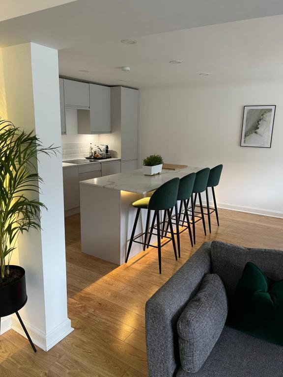 uma sala de estar com um sofá e uma cozinha em Lux 2 Bedroom Ground Floor Apartment em Edimburgo