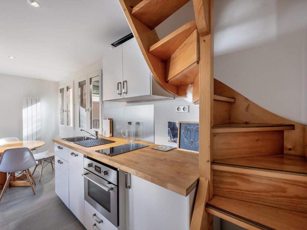 une cuisine avec des armoires blanches et un comptoir en bois dans l'établissement Appartement duplex cozy avec balcon et garage à Courchevel - FR-1-563-87, à Courchevel