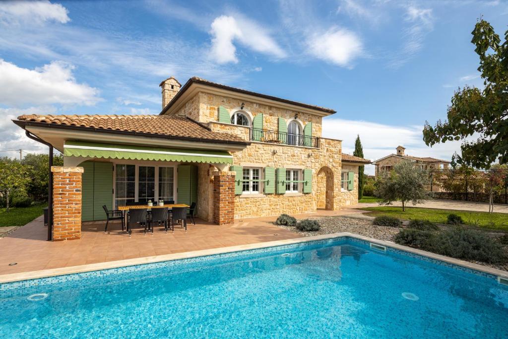 a house with a swimming pool in front of a house at Villa Perla in Krk