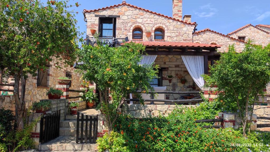 a stone house with trees in front of it at Artemis Stone House in Psakoudia