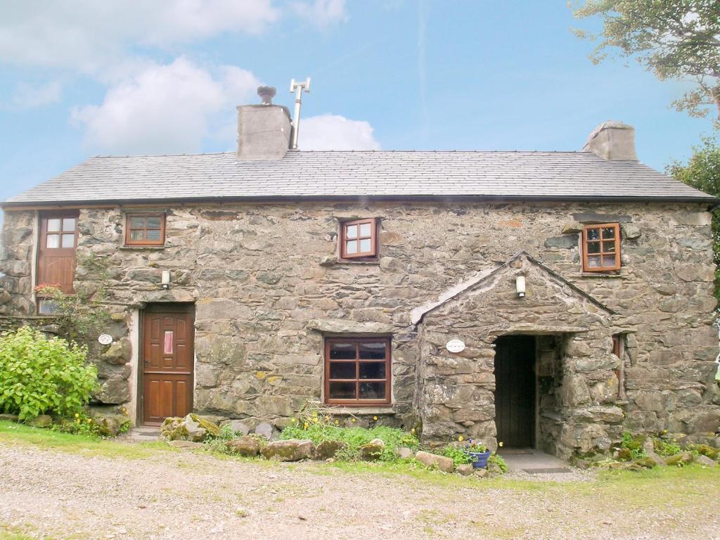 an old stone house with wooden doors and windows at Ganny House- Lvl in Eskdale