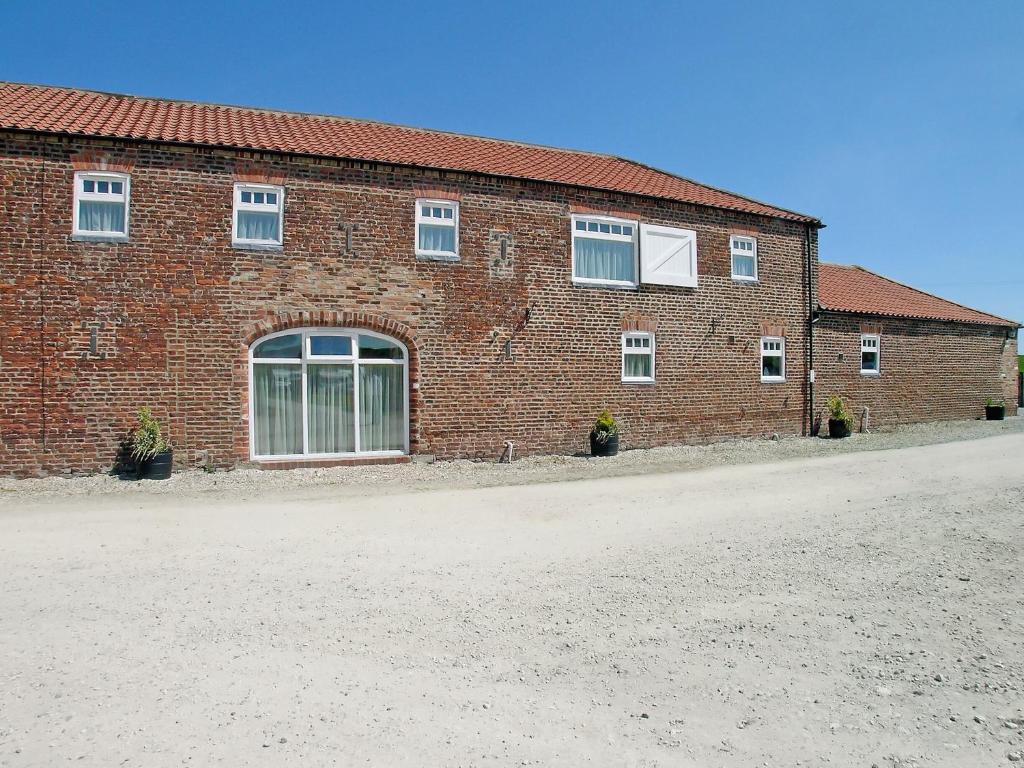 a brick building with windows on the side of it at Seagull Cottage in Flamborough