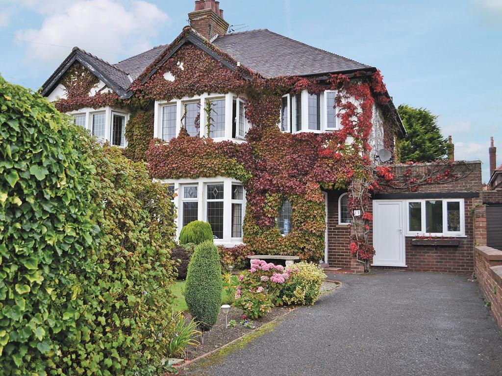 a house covered in ivy with a driveway at Ivy House in Saint Annes on the Sea