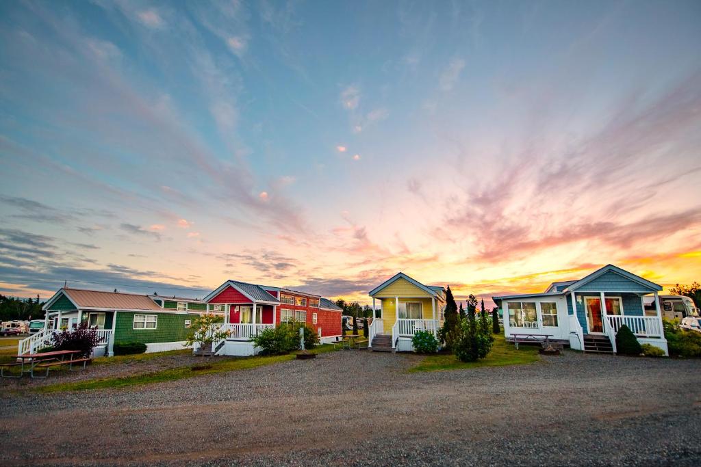 a row of houses with a sunset in the background at Narrows Too Camping Resort Loft Cottage 12 in Trenton