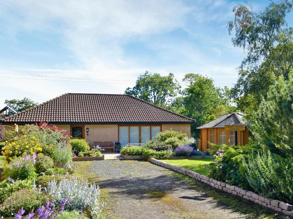 une maison avec un jardin en face dans l'établissement Eilean Donan, à Kirknewton