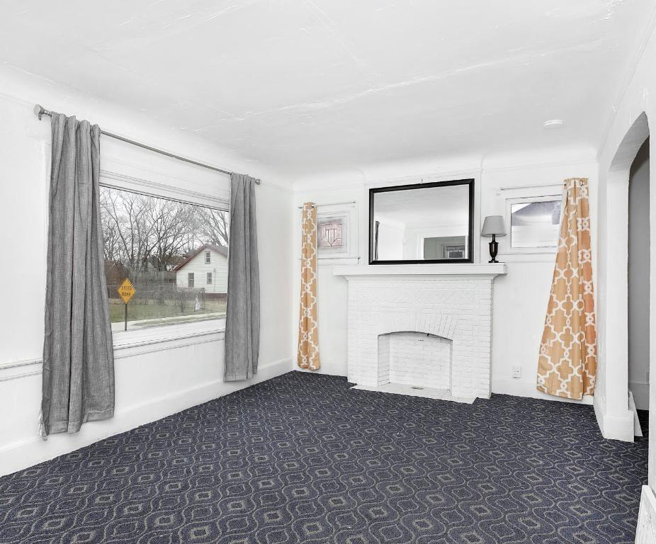 sala de estar con chimenea y ventana en A cozy home with fire place, en Detroit