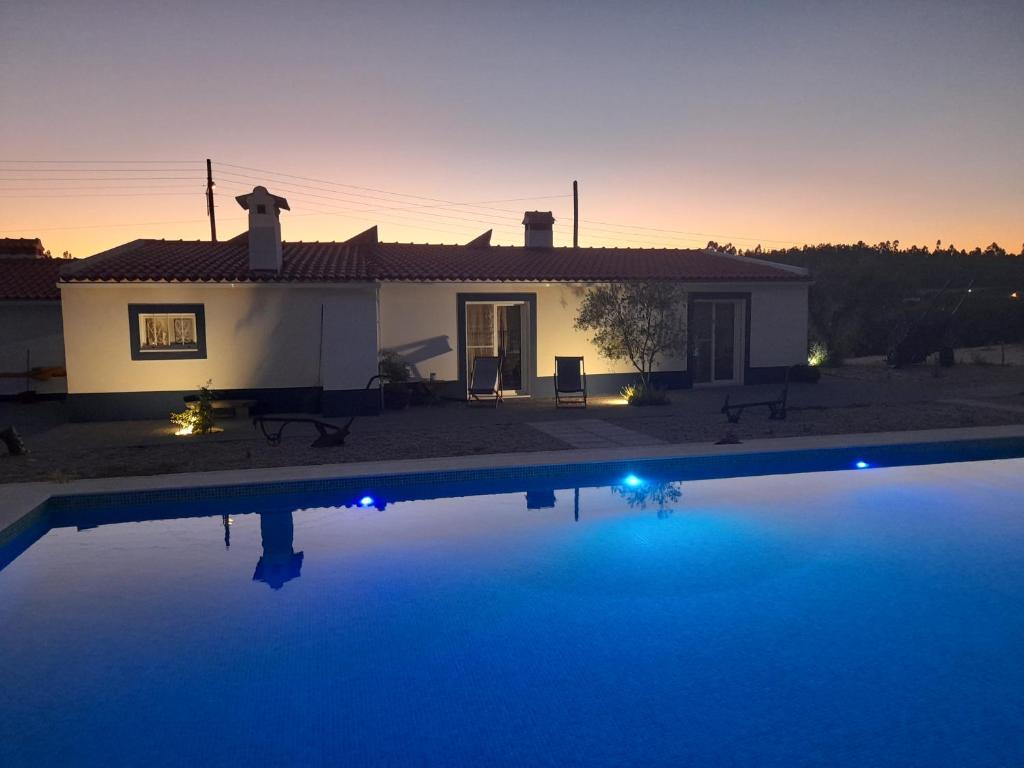 a house with a swimming pool at night at Monte das Rolas - A Serenidade mora Aqui! in Ferraria