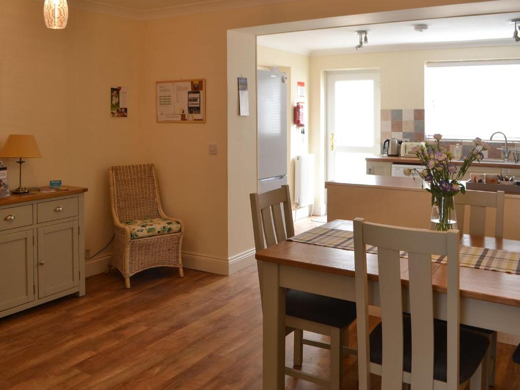 a kitchen and dining room with a table and chairs at Kittiwakes in Amble