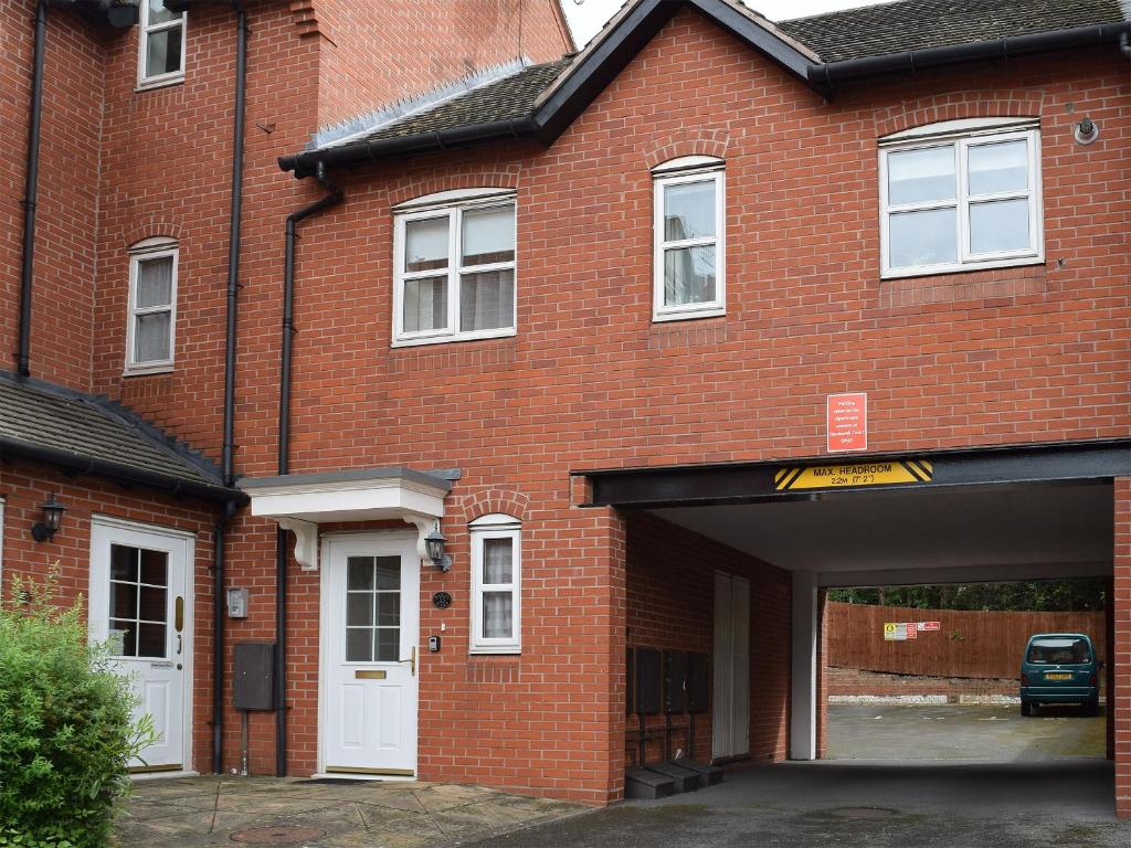 a brick building with a garage in front of it at Bards Well in Stratford-upon-Avon