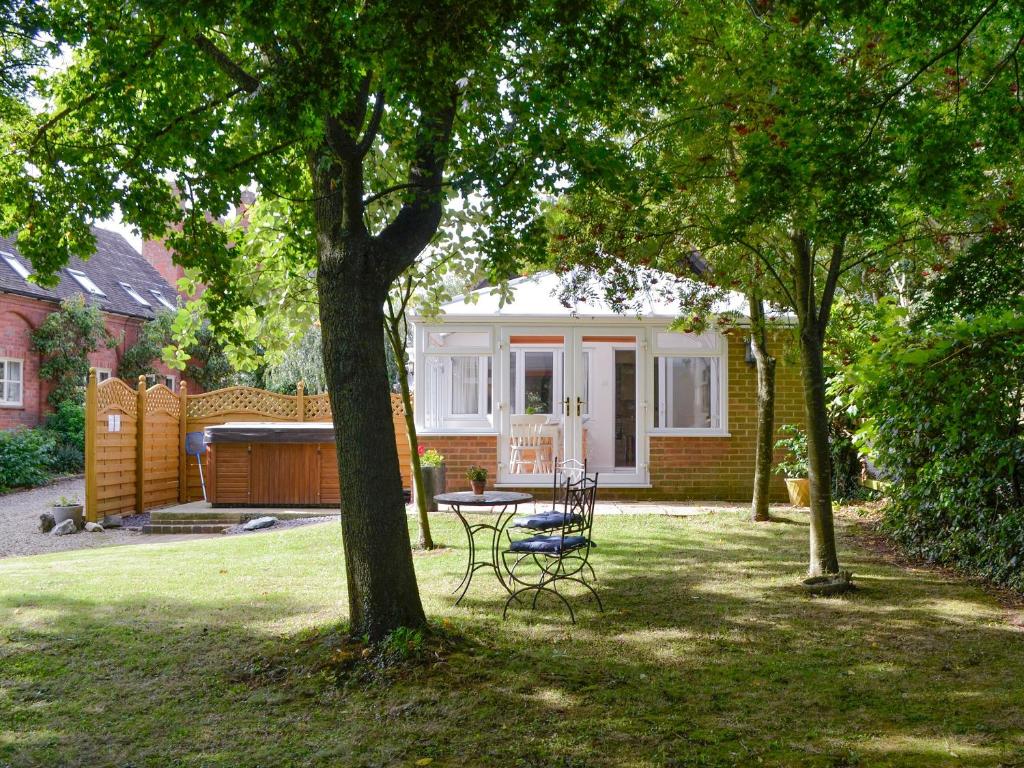 a house with a table and chairs in a yard at The Old Winery Cottage in Dymock