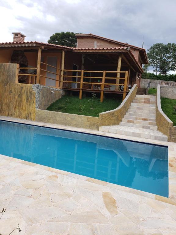 una casa con piscina frente a una casa en Chácara Picapau Amarelo en Socorro