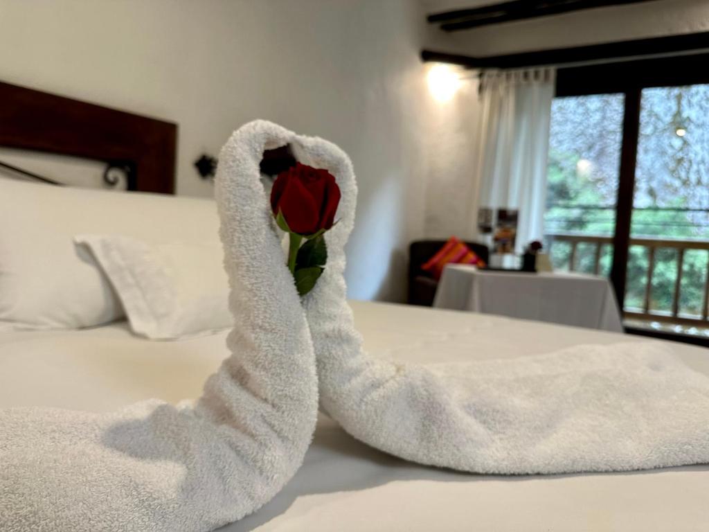 a towel animal shaped like a rose sitting on a bed at Hatun Inti Boutique in Machu Picchu