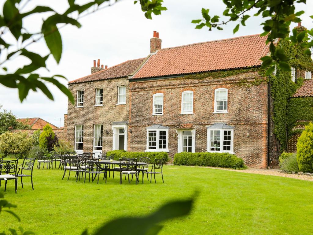 a large brick building with tables and chairs in the yard at Manor House in York
