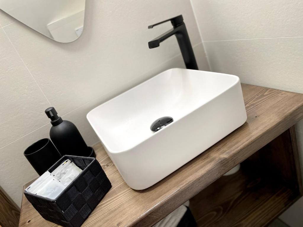 a white sink on a wooden counter in a bathroom at Hidden Cabin in Brezoi