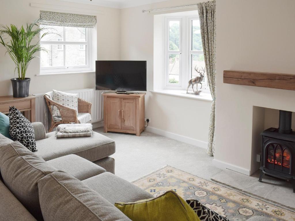 uma sala de estar com um sofá e uma lareira em Halfehill Cottage em Richmond