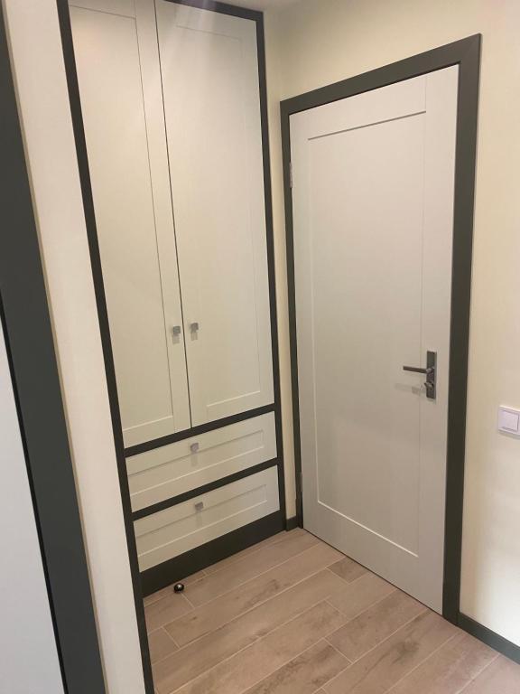 a closet with white cabinets and a mirror at Apartments in Kauguri in Jūrmala