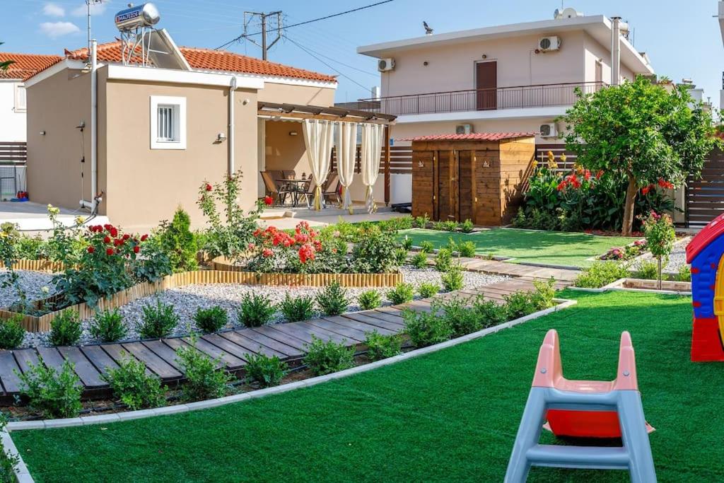 un patio trasero con un jardín con césped verde y una casa en Garden house en Neápolis