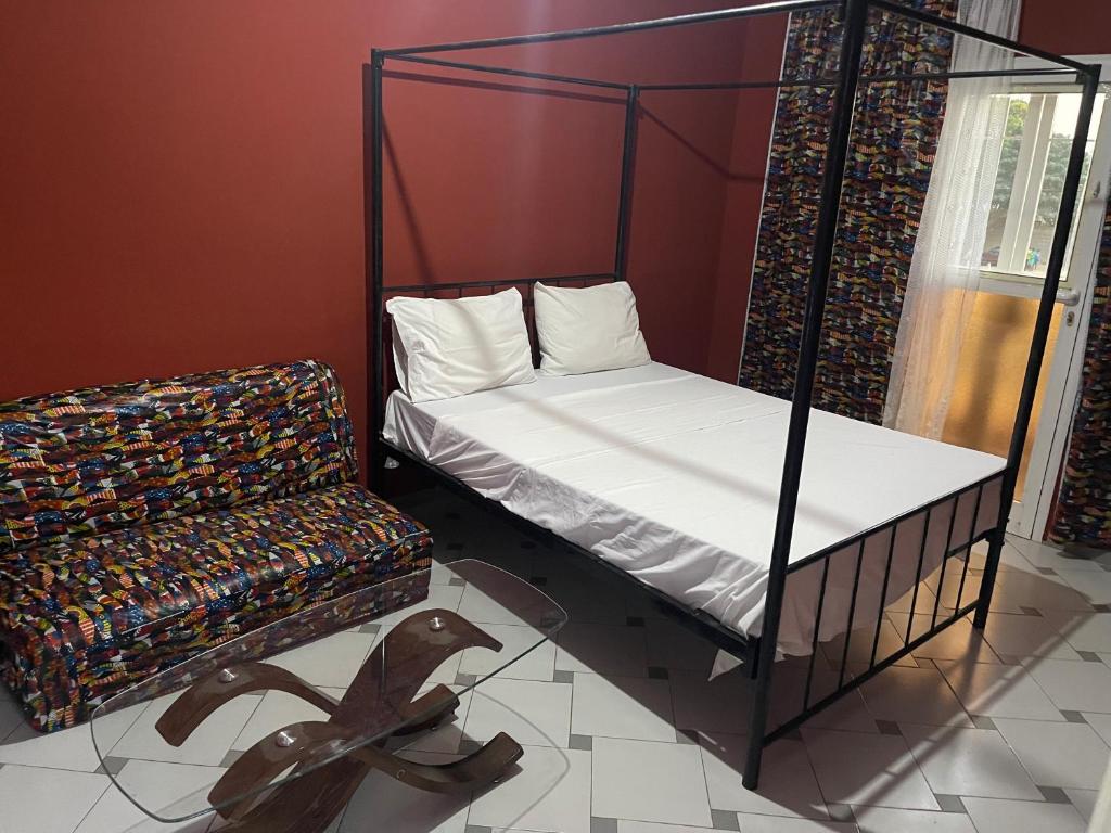 - une chambre avec un lit et une statue de chien à l'étage dans l'établissement Keur Karim sarr chambre d hôtes, à Mbour