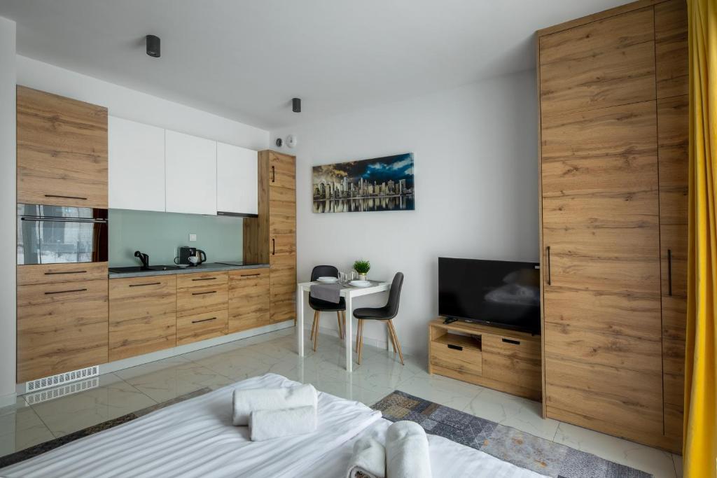 1 dormitorio con cama, mesa y TV en Apartament Ażurowy, en Kudowa-Zdrój
