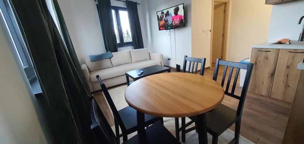 un salon avec une table et des chaises en bois dans l'établissement MONTANA apartment 21, à Kopaonik