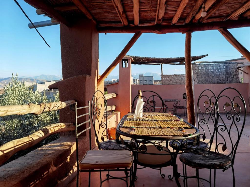 een tafel en stoelen op een balkon met uitzicht bij Dar Boumida in Lalla Takerkoust