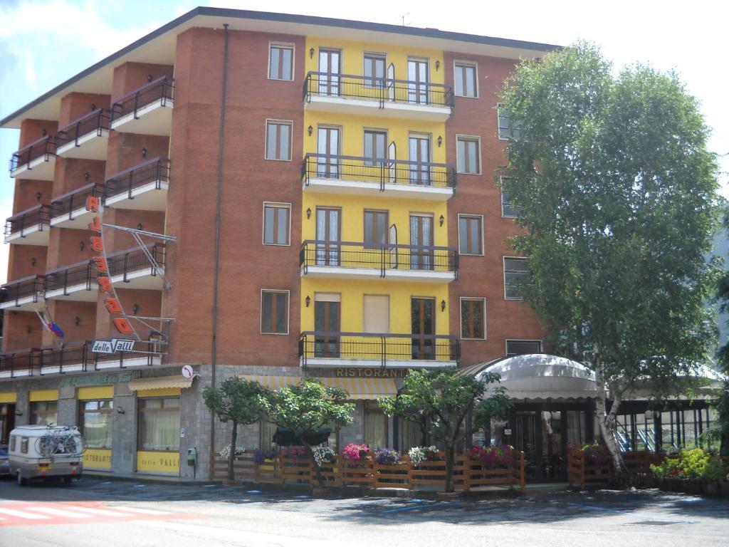 een groot appartementencomplex met een gele bij HOTEL RISTORANTE DELLE VALLI in Germagnano