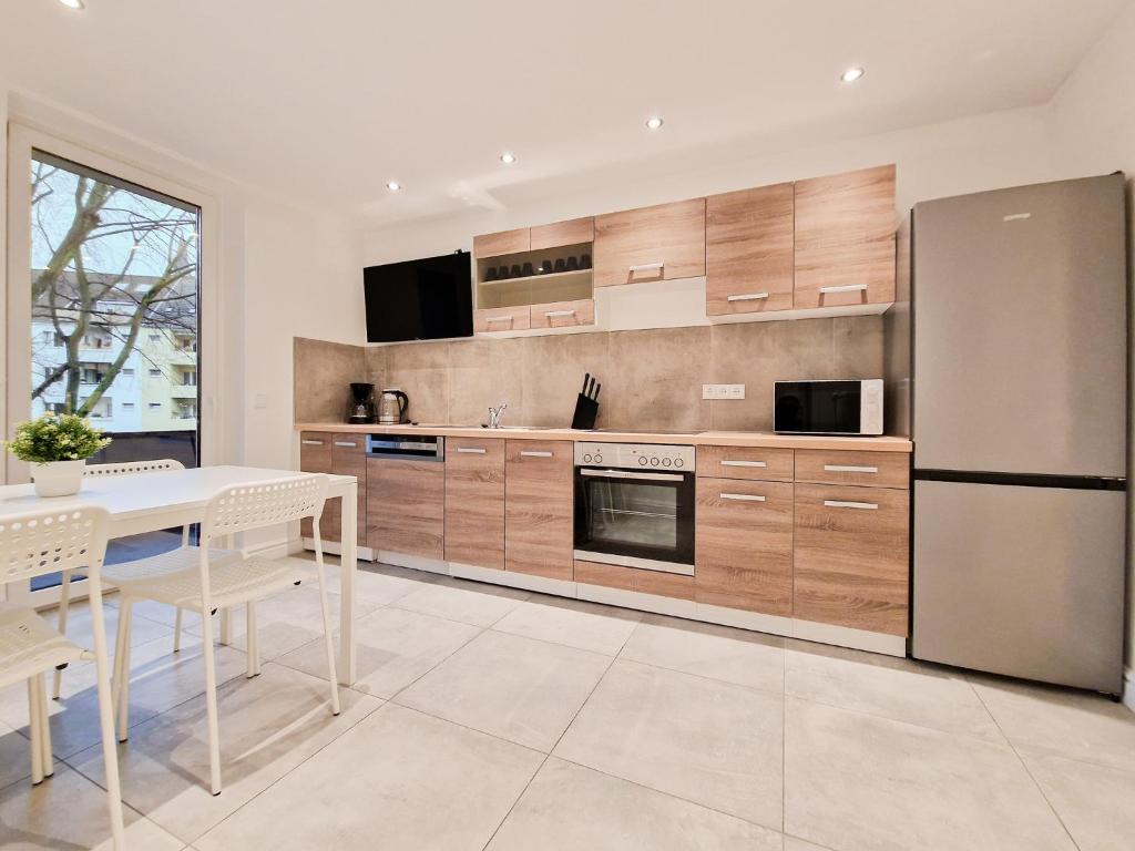 eine Küche mit einem weißen Tisch und einem Kühlschrank in der Unterkunft Tolstov Apartments - City Apartments with 1 or 2 Rooms - 15 Min to Messe DUS and Old Town DUS in Düsseldorf